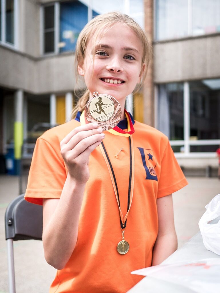 Girl holding her running medal